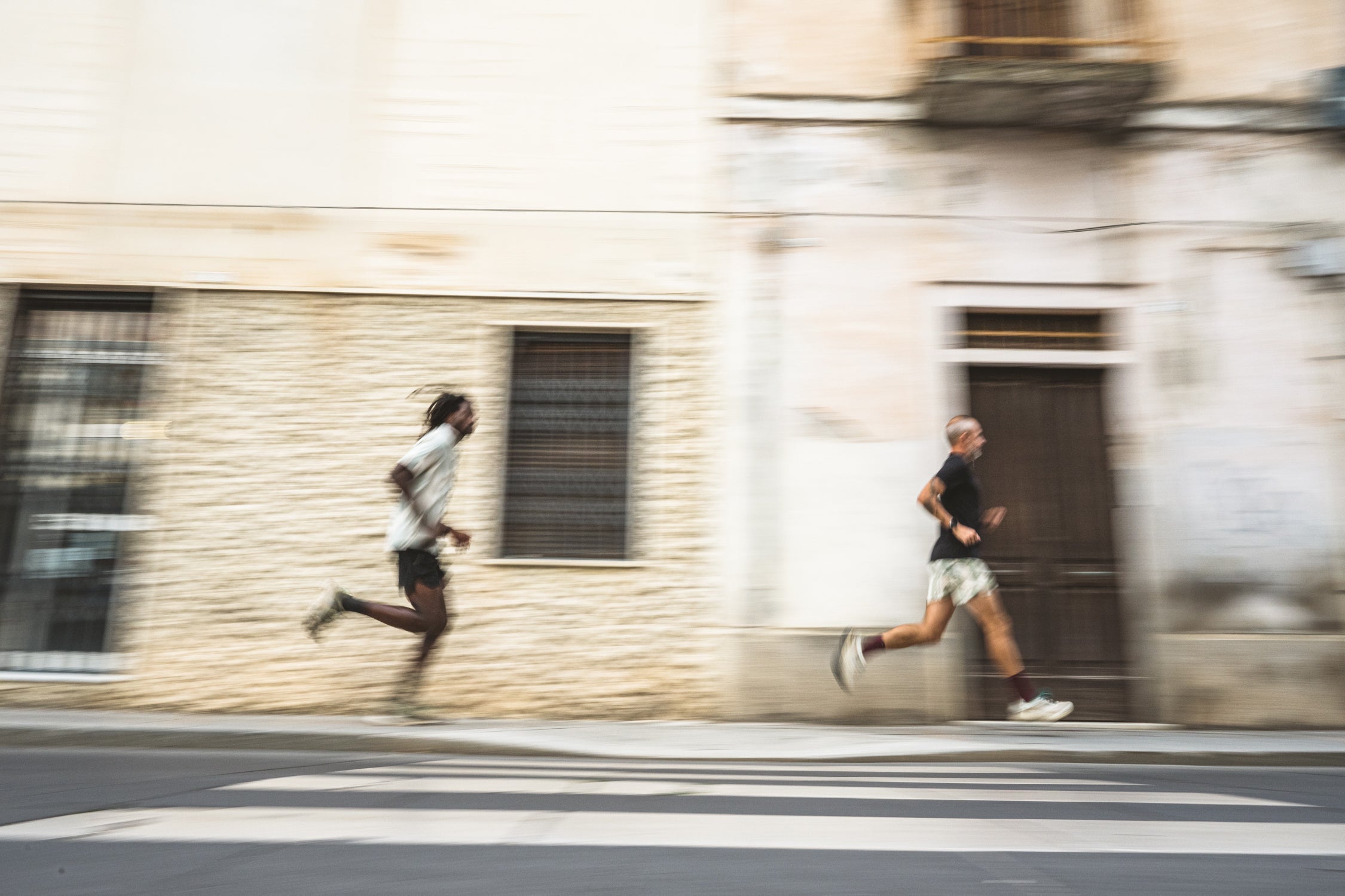 zwei Männer, die in Roark Run Amok-Kleidung durch die Straßen von Sardinien rennen