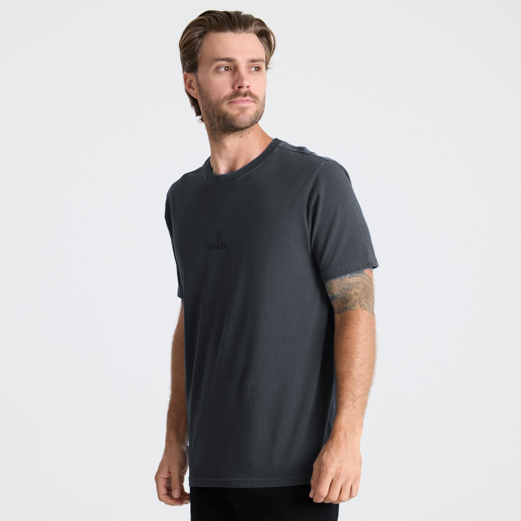 Grey active shirt designed for adventure and travel by Roark, displayed in a natural outdoor setting.